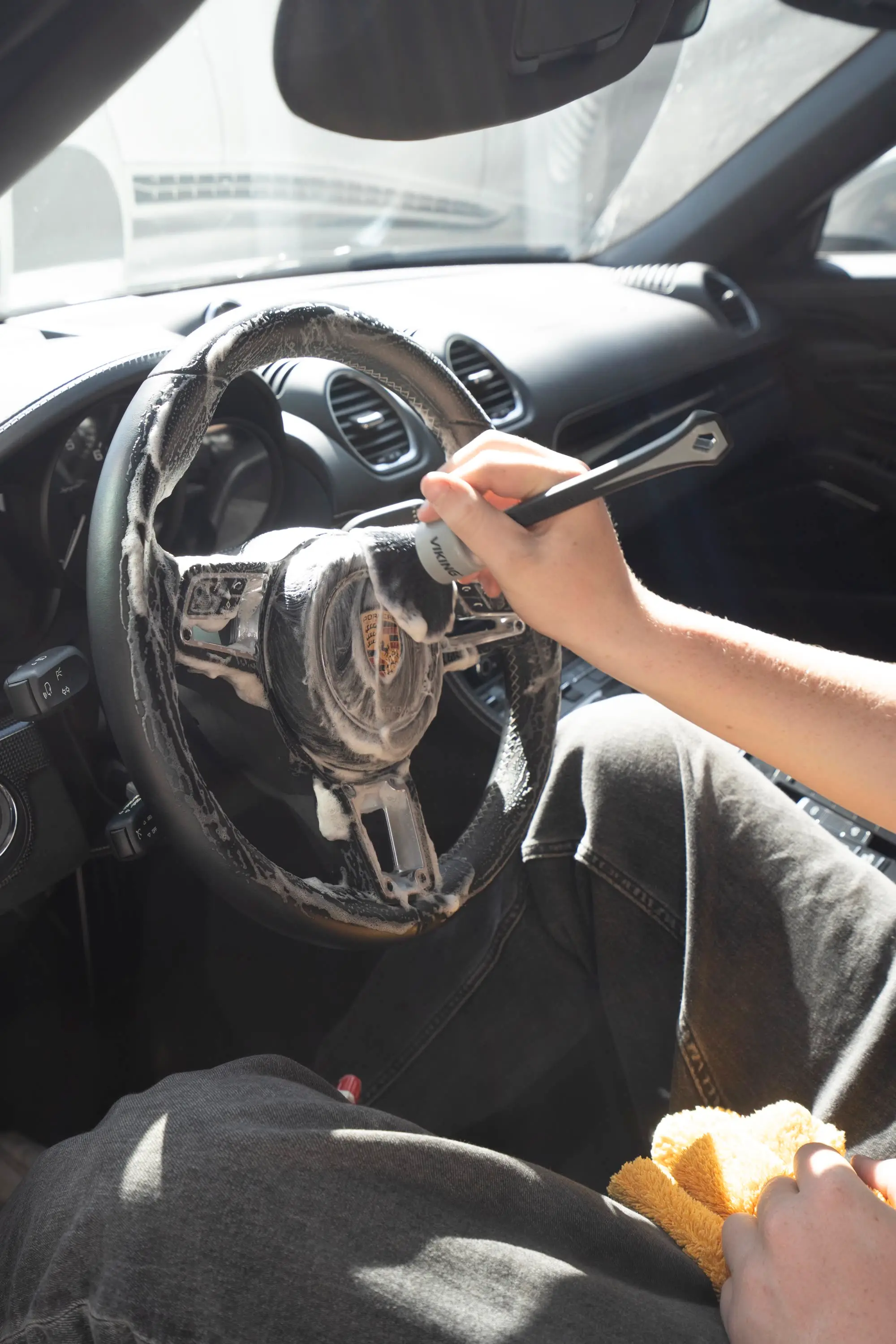 Porsche 718 Spyder, Steering wheel of Porsche 718 being deep-cleaned with foam brush