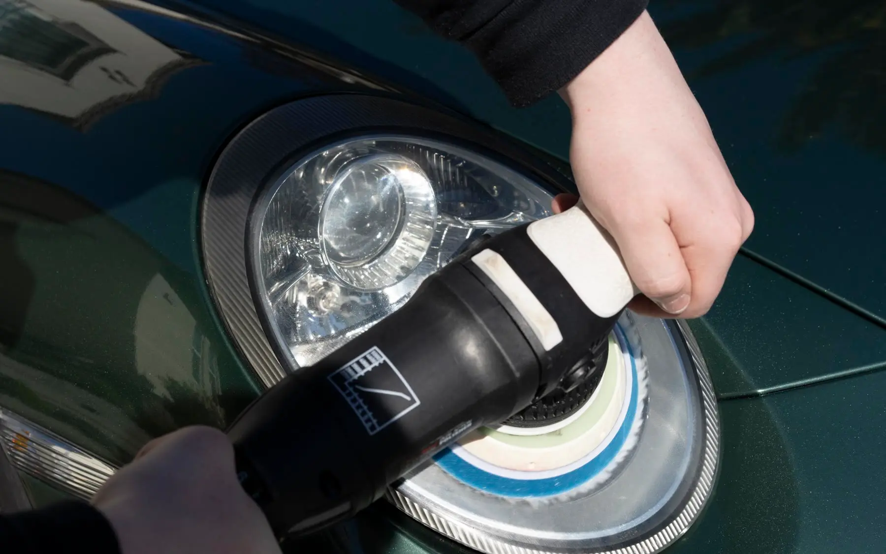 Hazy, oxidized headlight on a green Porsche 911 mid-restoration