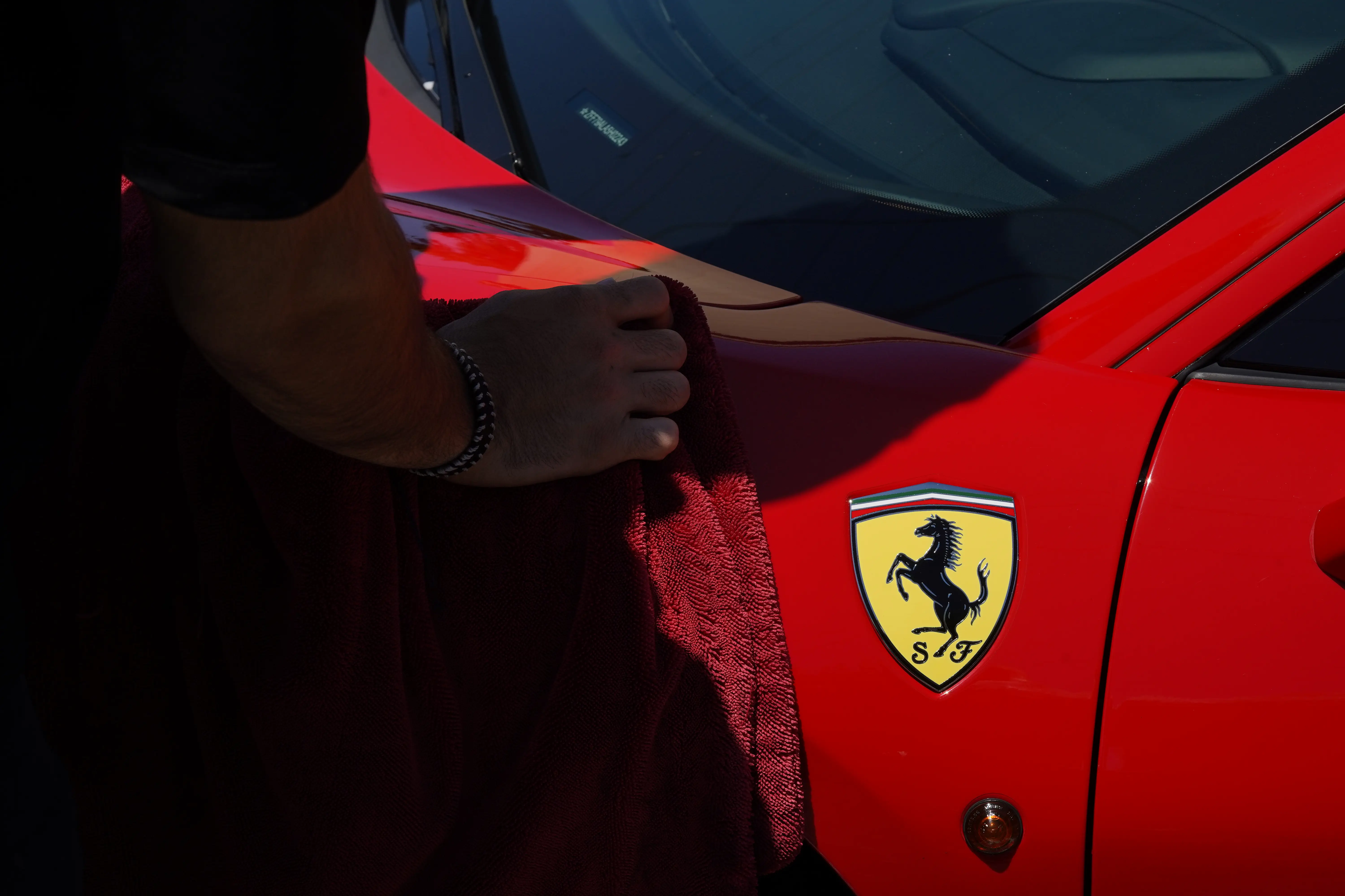 Hand-finishing the fender of a red Ferrari 488