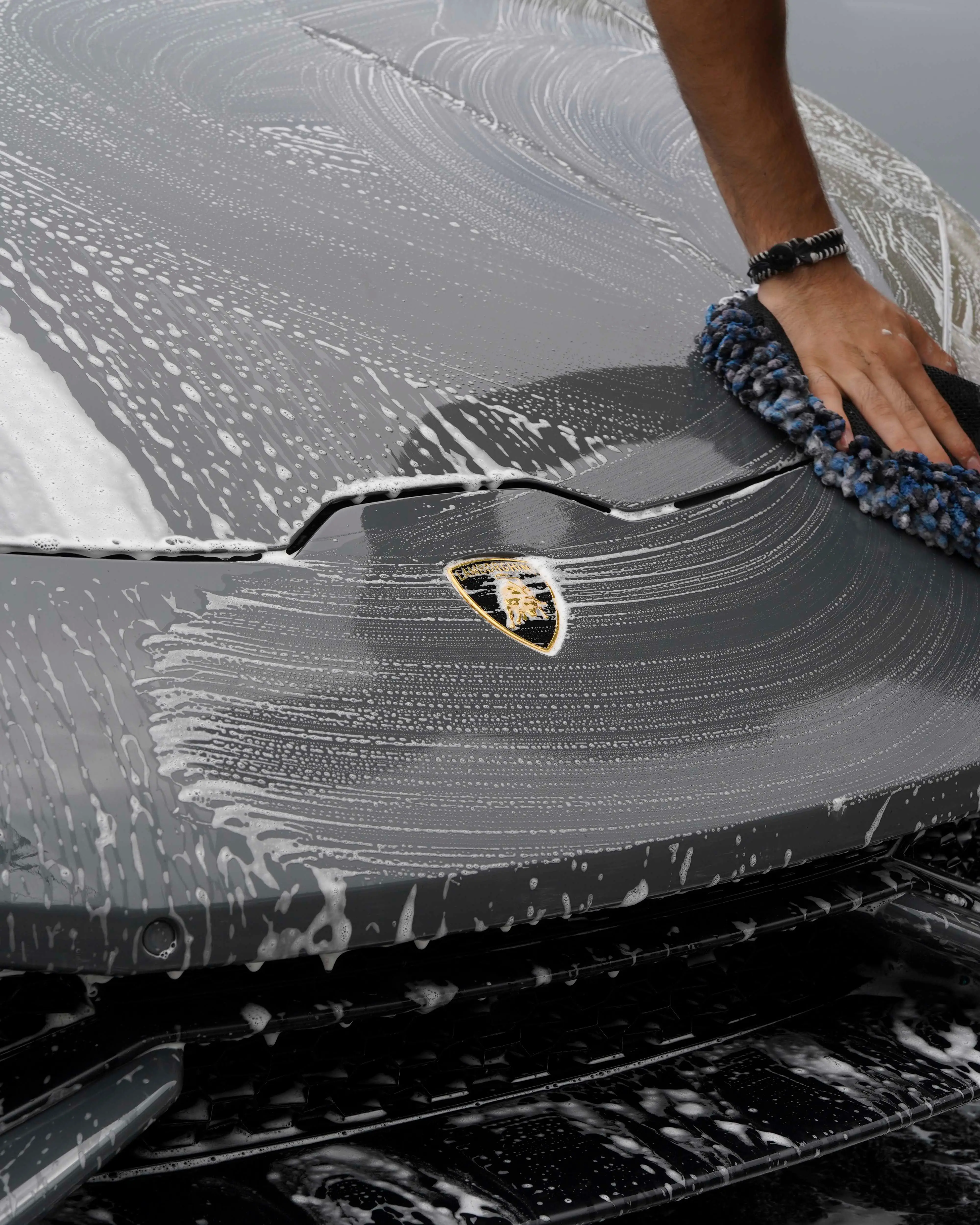 Wash mitt gliding over a foamed Lamborghini Huracán hood
