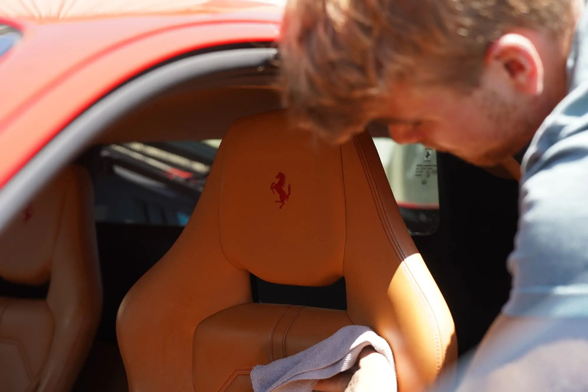 Ferrari 488 GTB, Detailer wiping tan leather Ferrari seat